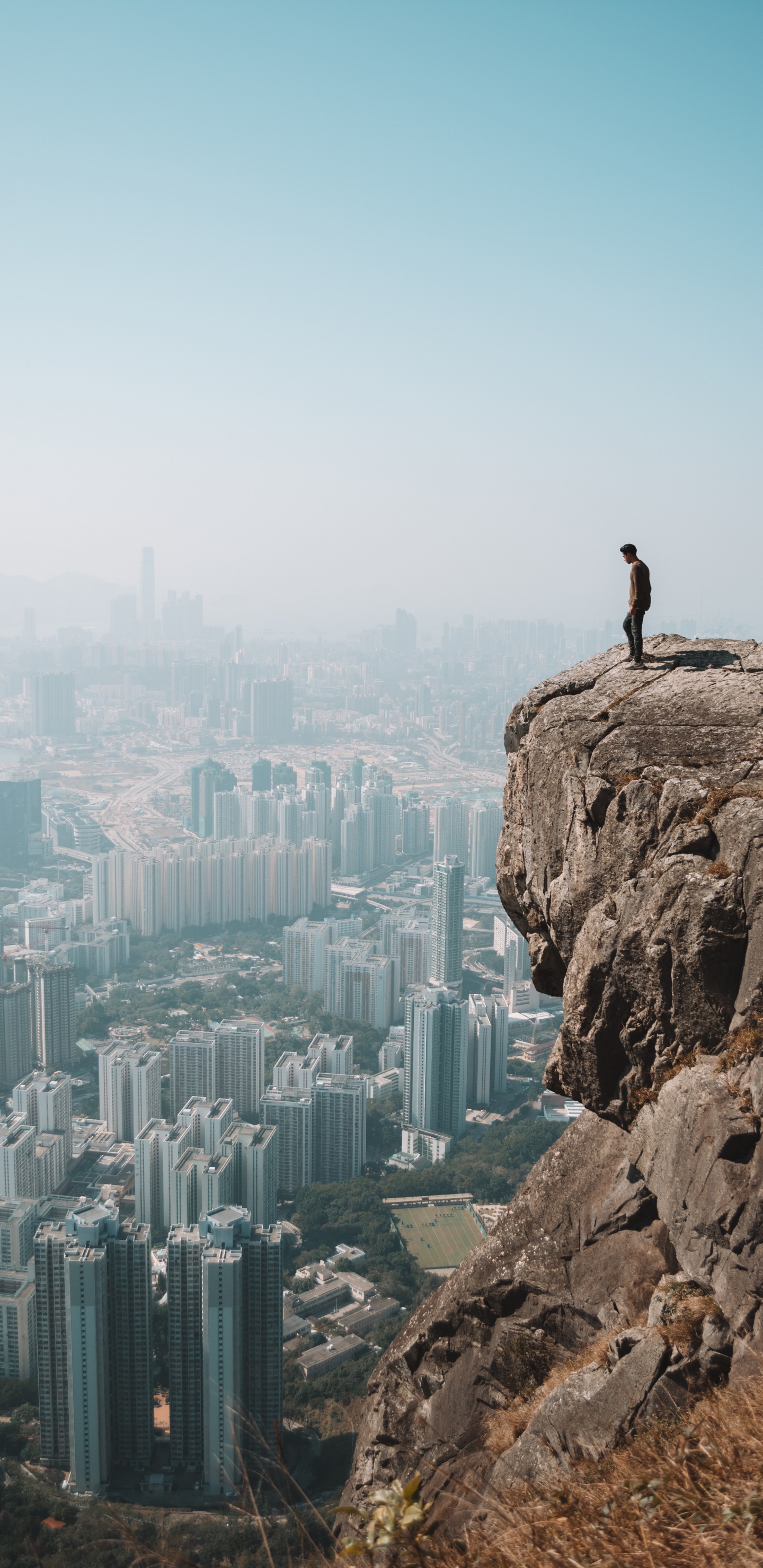 Homme Debout Sur Une Formation Rocheuse Pendant la Journée. Wallpaper in 1440x2960 Resolution