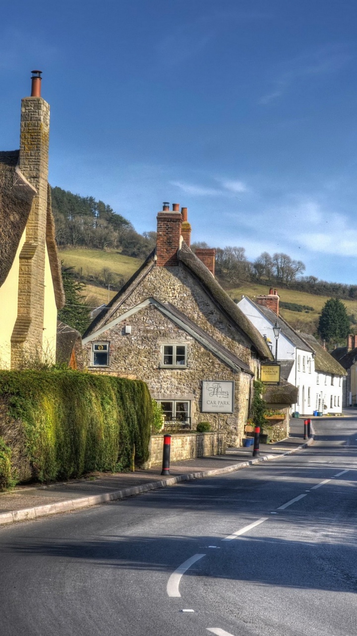 Brown and White Concrete House Beside Road Under Blue Sky During Daytime. Wallpaper in 720x1280 Resolution