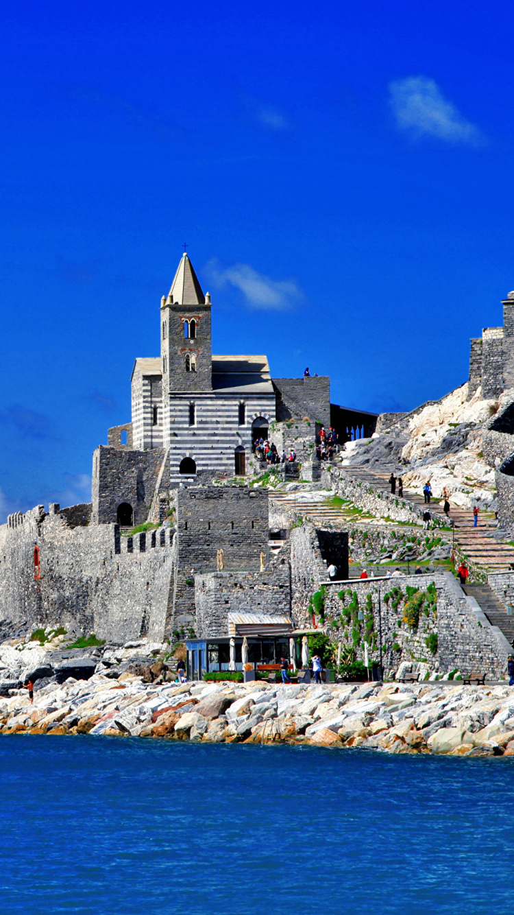 Gray Concrete Building Near Body of Water During Daytime. Wallpaper in 750x1334 Resolution
