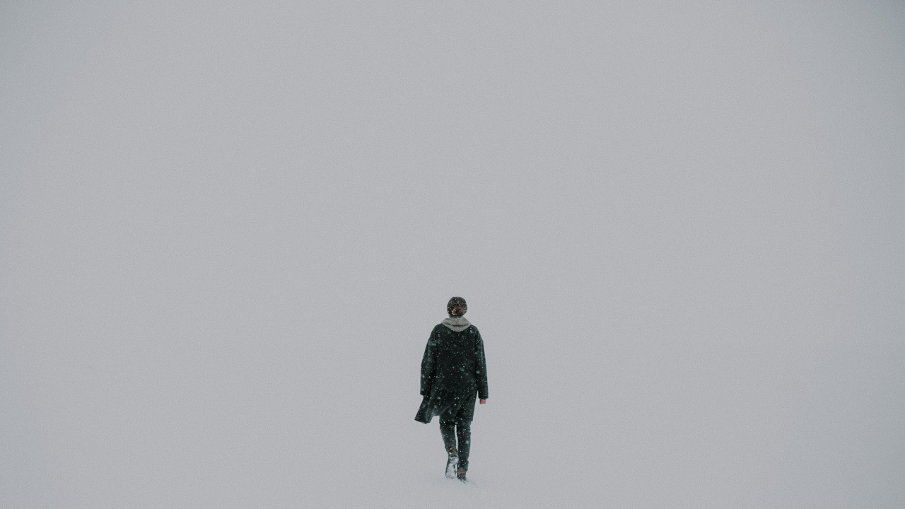 Man in Black Jacket Standing on Snow Covered Ground. Wallpaper in 1280x720 Resolution