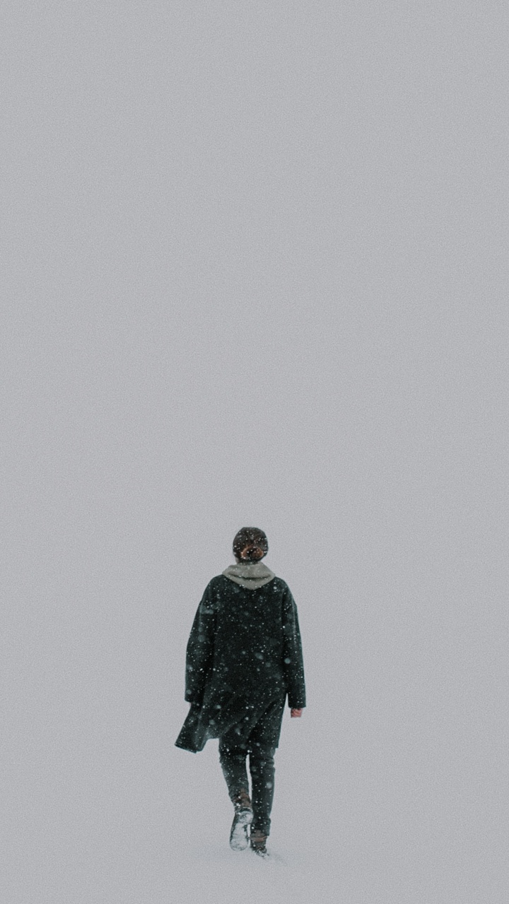 Man in Black Jacket Standing on Snow Covered Ground. Wallpaper in 720x1280 Resolution