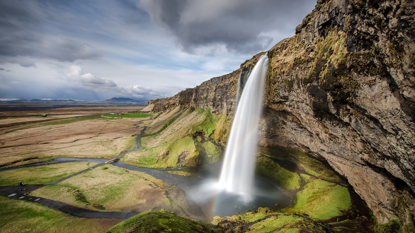 Waterfalls on Green Grass Field Under Gray Cloudy Sky During Daytime. Wallpaper in 1366x768 Resolution