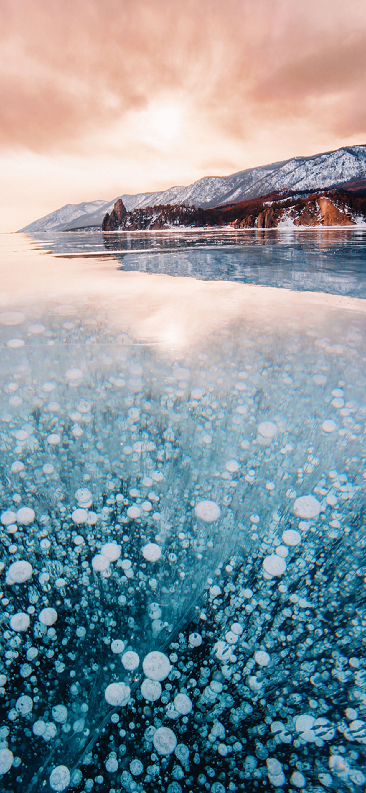 Person Standing on Snow Covered Ground Near Mountain During Daytime. Wallpaper in 1242x2688 Resolution