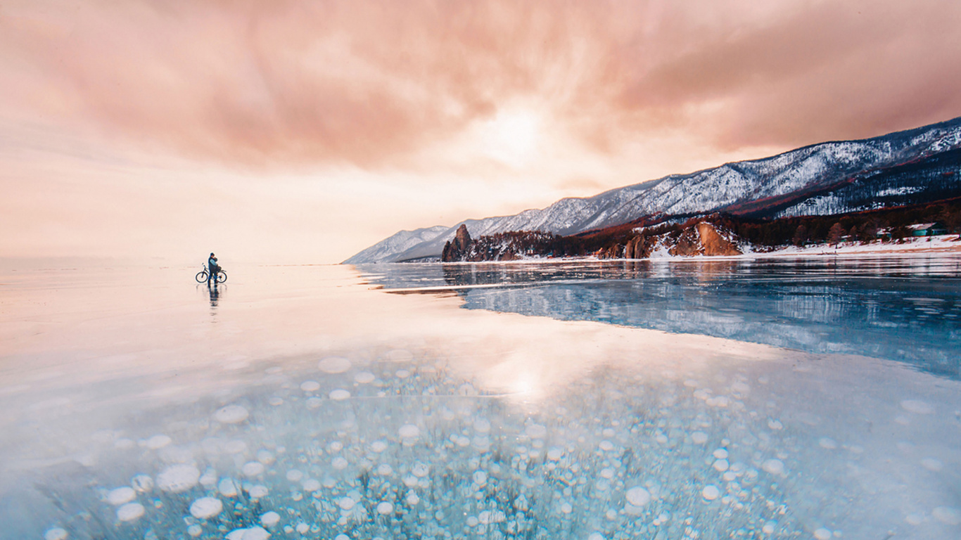 Person Standing on Snow Covered Ground Near Mountain During Daytime. Wallpaper in 1366x768 Resolution