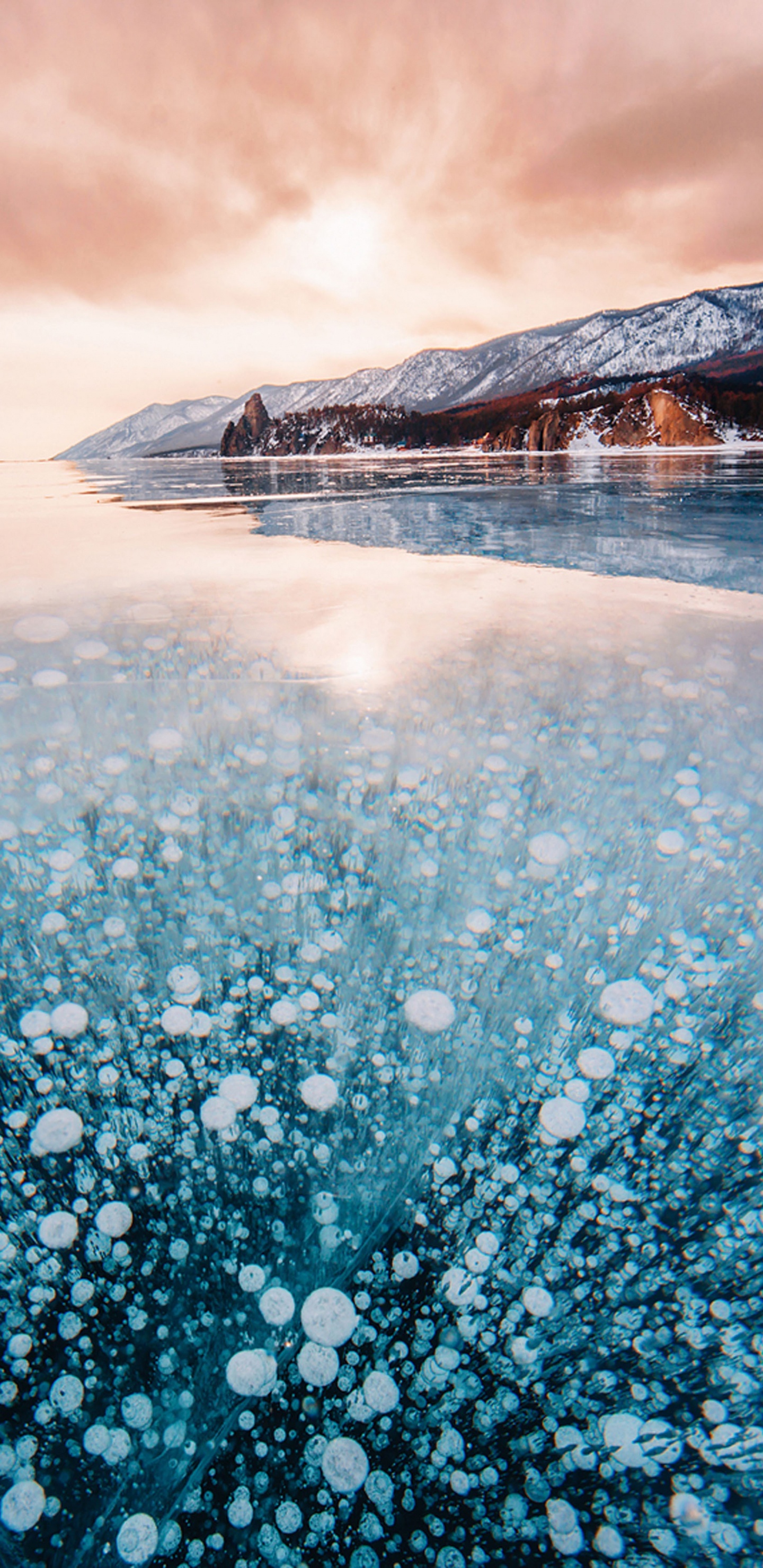 Person Standing on Snow Covered Ground Near Mountain During Daytime. Wallpaper in 1440x2960 Resolution