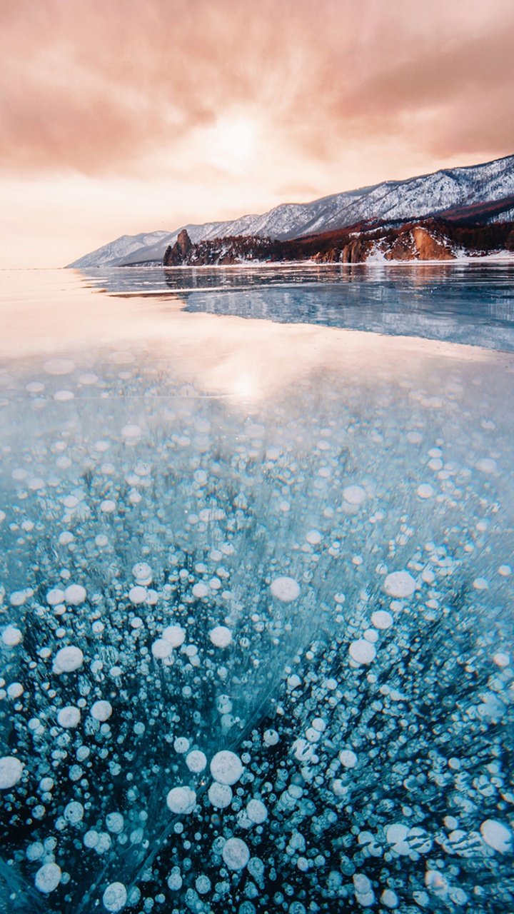 Person Standing on Snow Covered Ground Near Mountain During Daytime. Wallpaper in 720x1280 Resolution