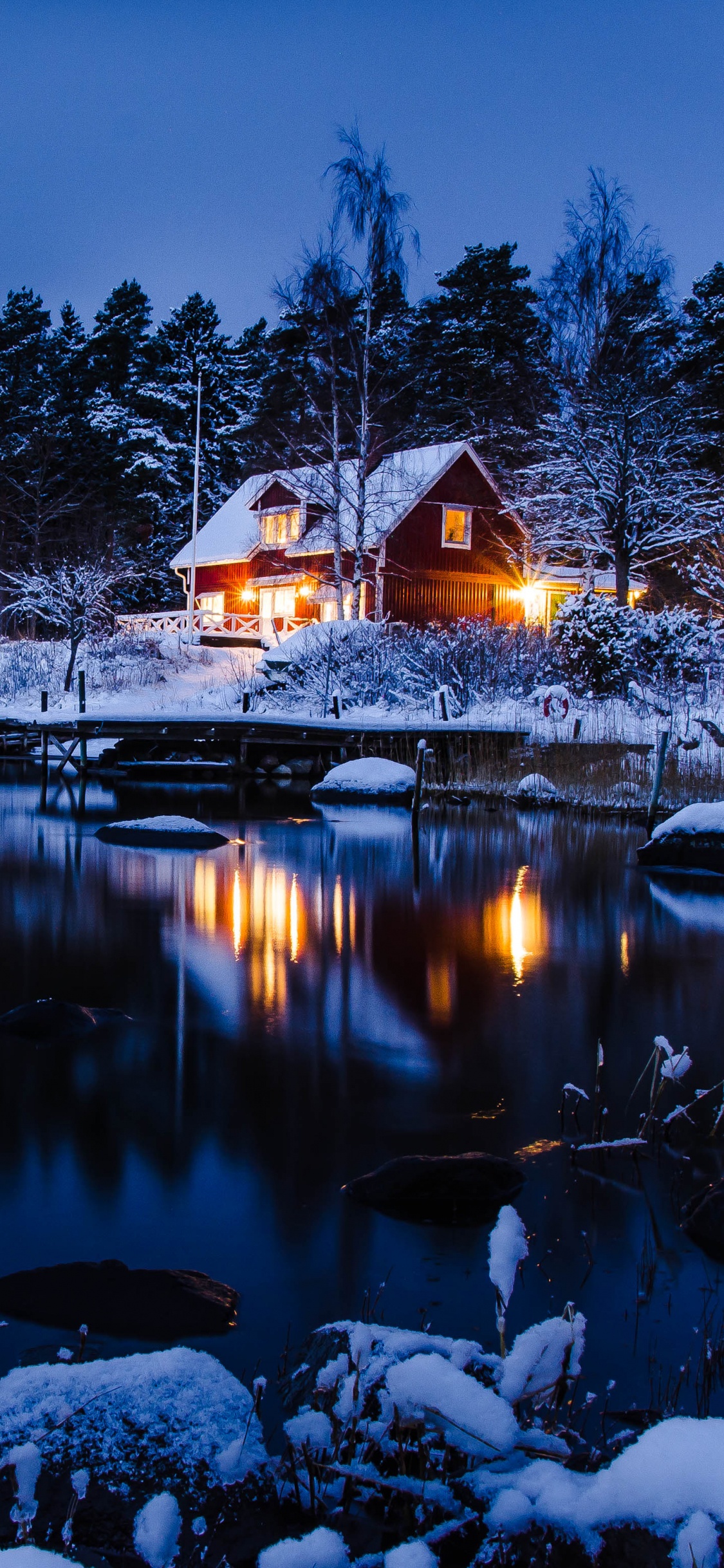 Maison Brune et Blanche Près D'un Plan D'eau Pendant la Nuit. Wallpaper in 1125x2436 Resolution