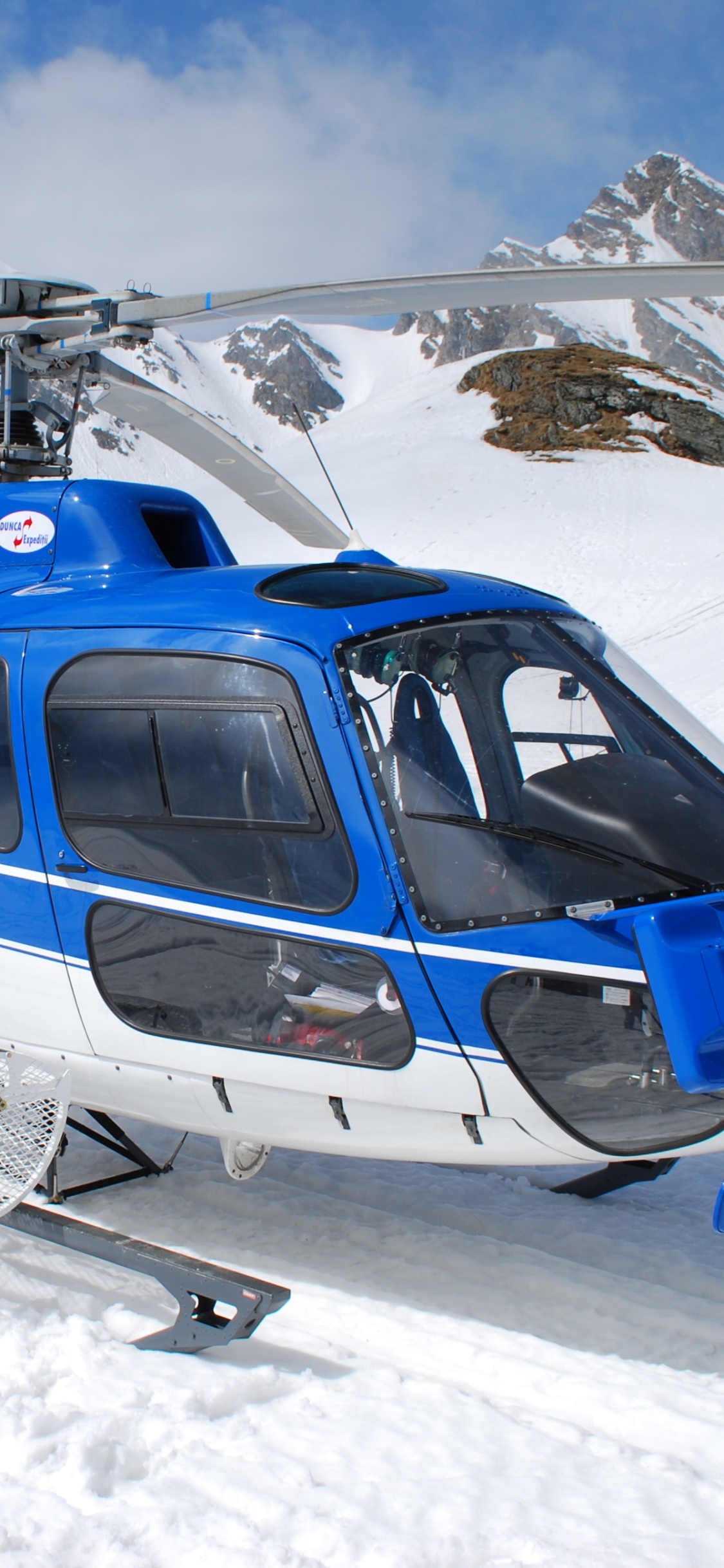 Blue and White Helicopter on Snow Covered Ground During Daytime. Wallpaper in 1125x2436 Resolution