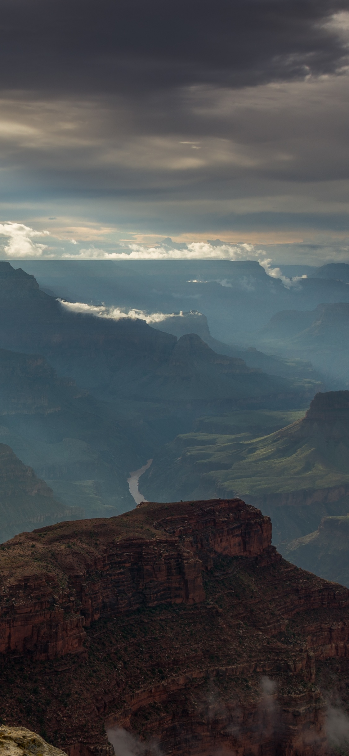 Brauner Felsiger Berg Unter Weißen Wolken Tagsüber. Wallpaper in 1125x2436 Resolution