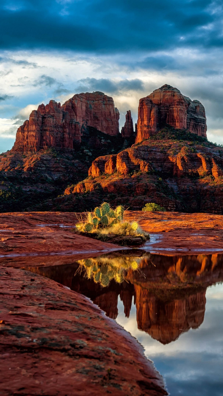 Brown Rock Formation Beside Body of Water Under Cloudy Sky During Daytime. Wallpaper in 750x1334 Resolution