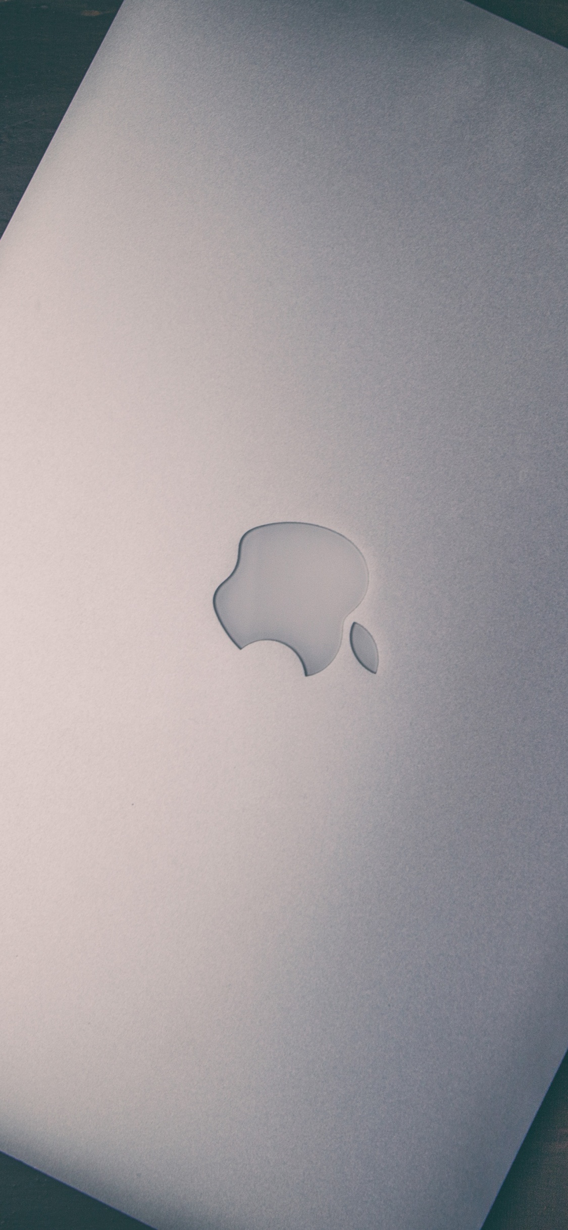 Silbernes MacBook Auf Braunem Holztisch. Wallpaper in 1125x2436 Resolution