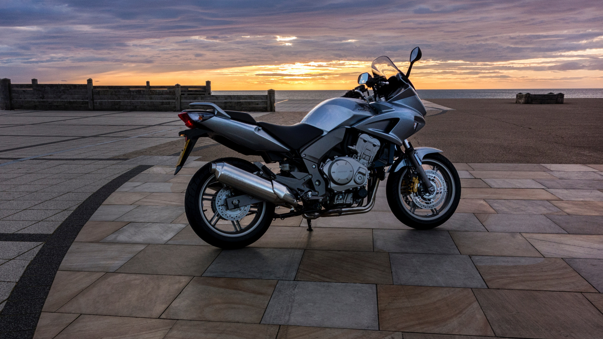 Schwarz-silbernes Cruiser-Motorrad Auf Grauer Betonstraße Bei Sonnenuntergang. Wallpaper in 1920x1080 Resolution