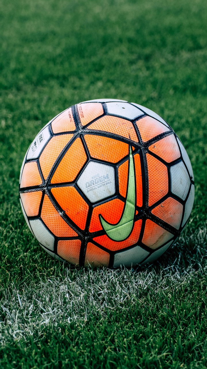 Orange and Black Soccer Ball on Green Grass Field During Daytime. Wallpaper in 720x1280 Resolution