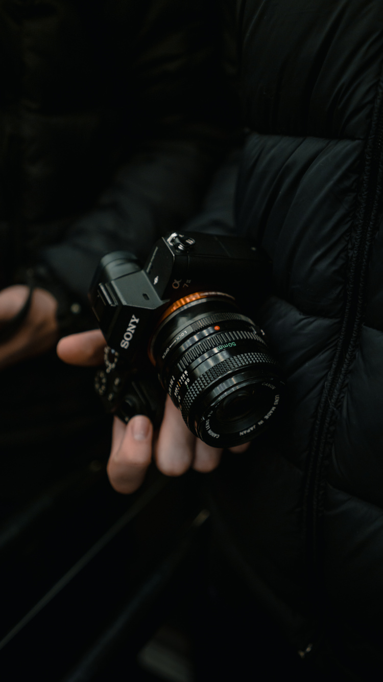 Person Holding Black Dslr Camera. Wallpaper in 750x1334 Resolution