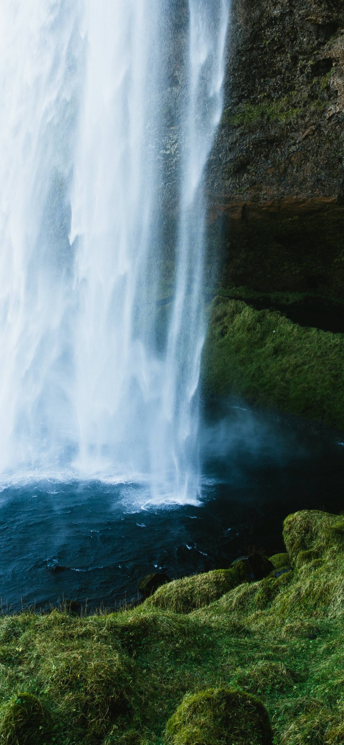 Cascadas en la Colina Cubierta de Hierba Verde Durante el Día. Wallpaper in 1125x2436 Resolution