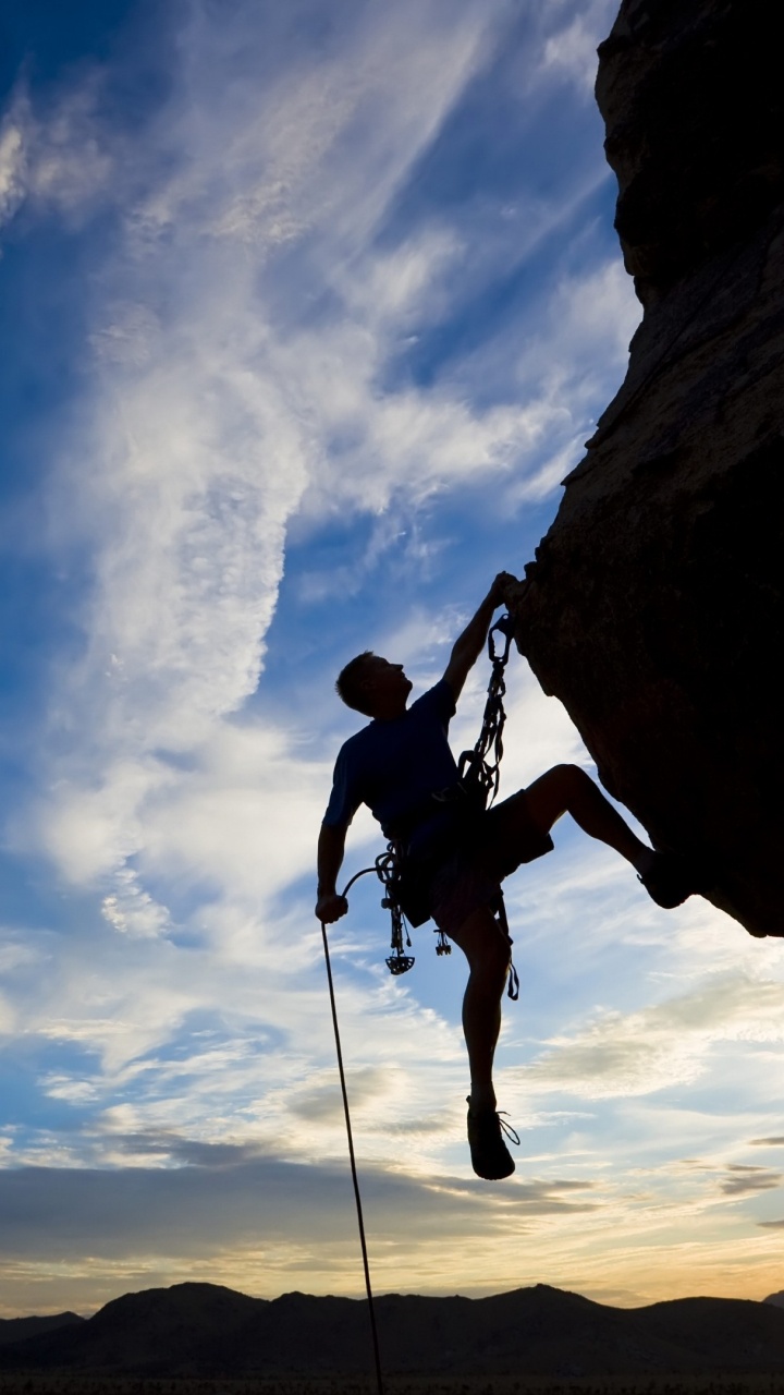 Man in Black Jacket and Black Pants Climbing on Brown Rock Mountain During Daytime. Wallpaper in 720x1280 Resolution