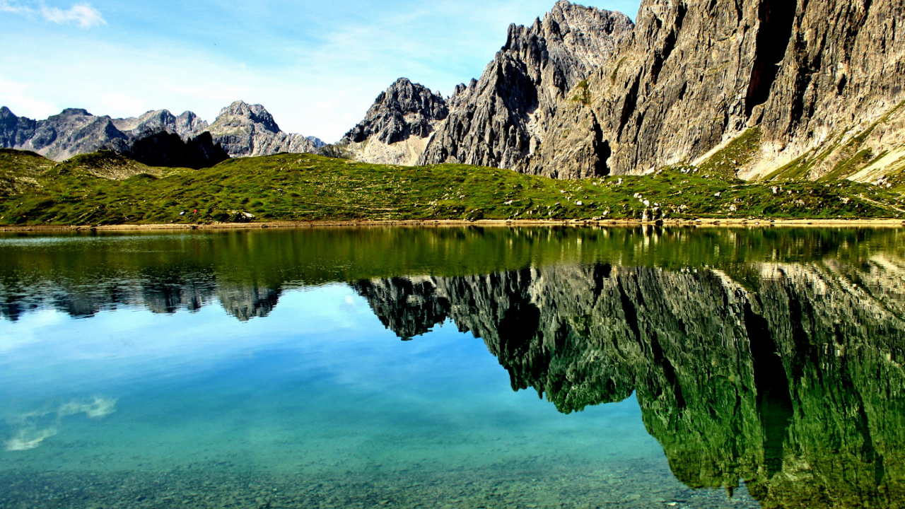 See in Der Nähe Des Berges Unter Blauem Himmel Tagsüber. Wallpaper in 1280x720 Resolution