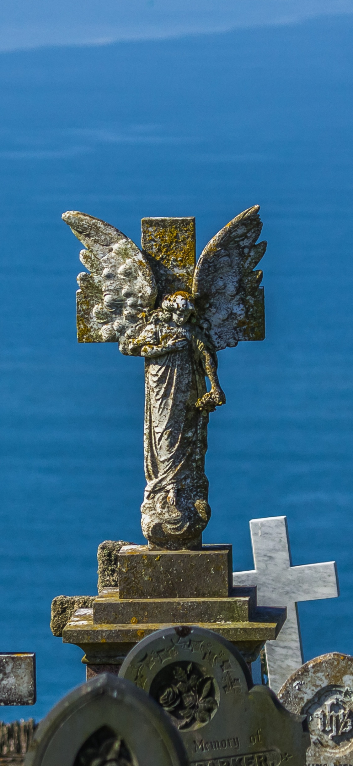 Estatua de la Cruz de Hormigón Gris Bajo un Cielo Azul Durante el Día. Wallpaper in 1125x2436 Resolution