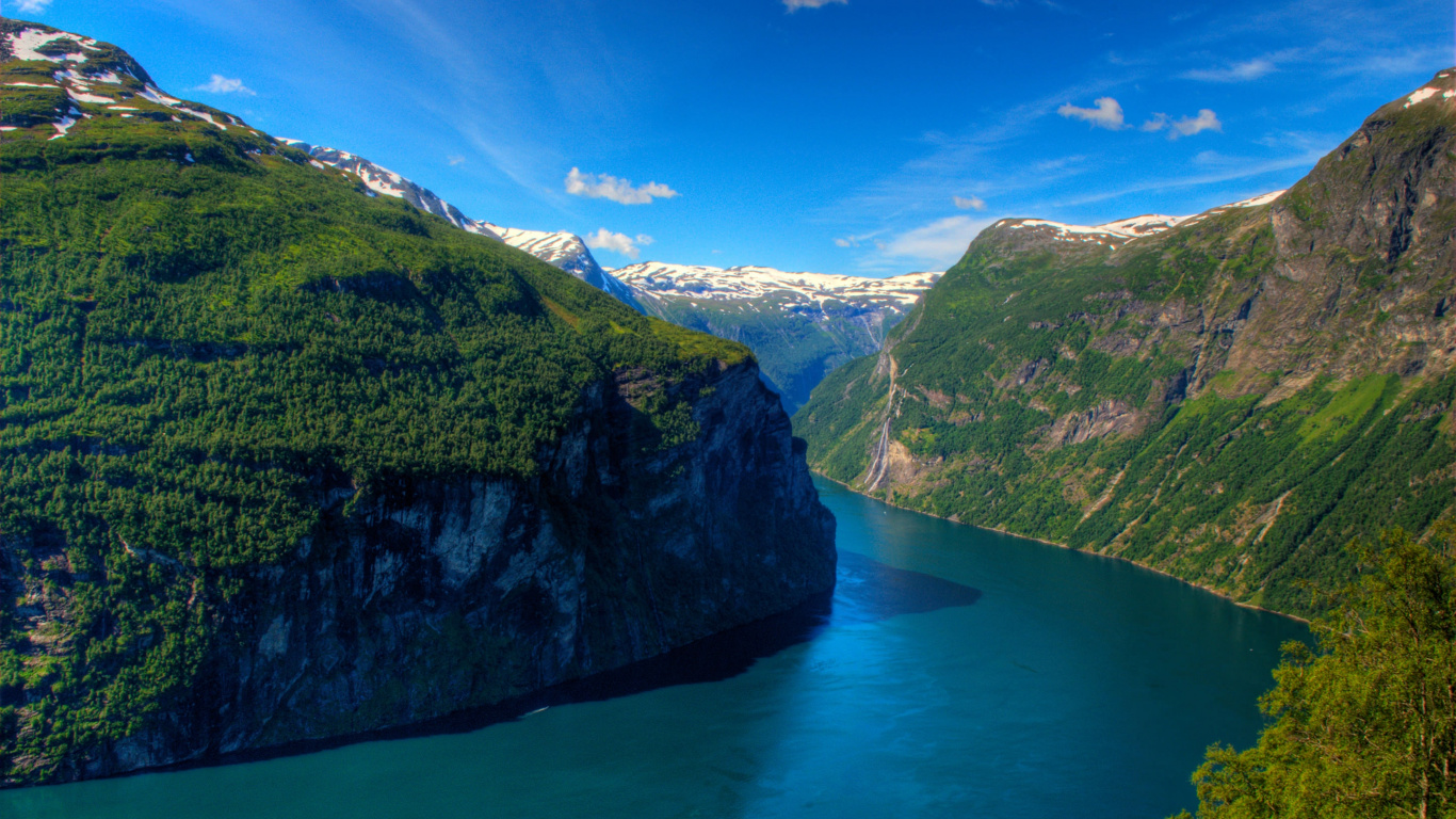 Montagne Verte à Côté du Lac Bleu Sous Ciel Bleu Pendant la Journée. Wallpaper in 1366x768 Resolution