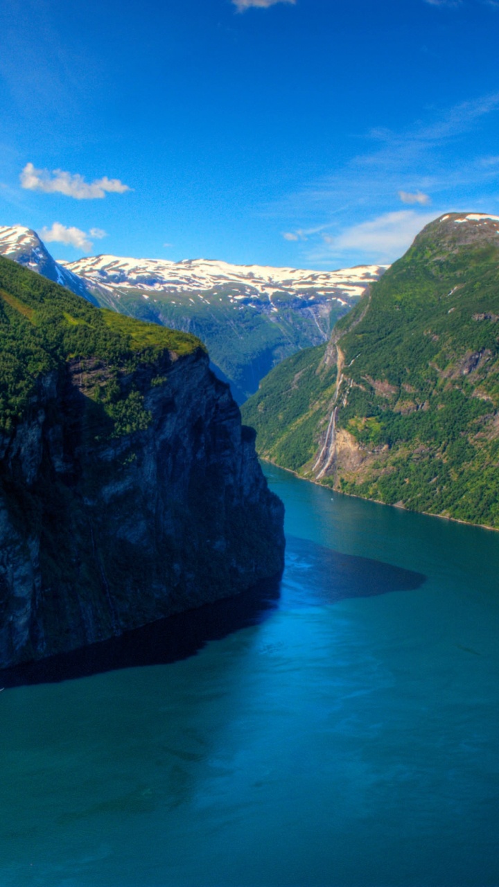 Green Mountain Beside Blue Lake Under Blue Sky During Daytime. Wallpaper in 720x1280 Resolution
