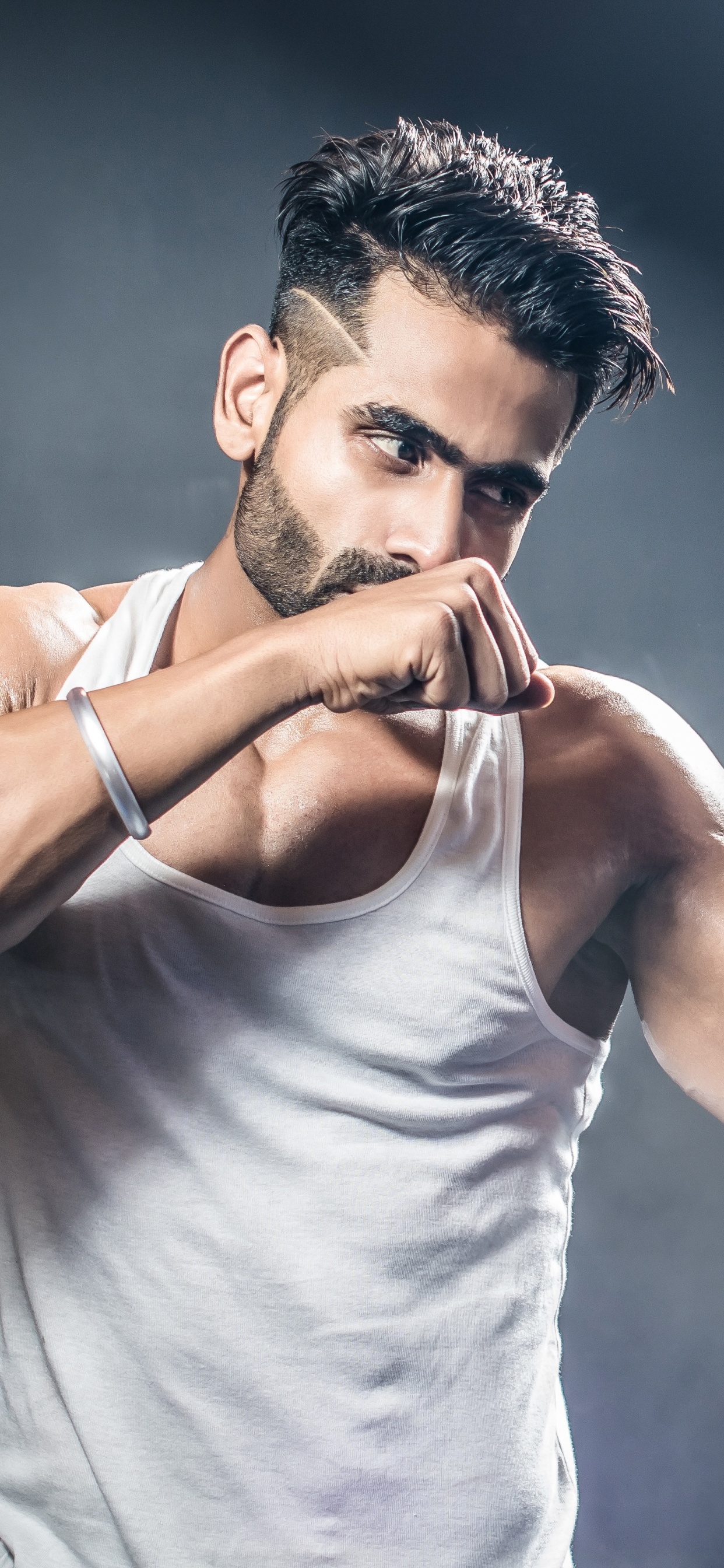 Man in White Tank Top Holding Blue and White Nike Boxing Gloves. Wallpaper in 1242x2688 Resolution