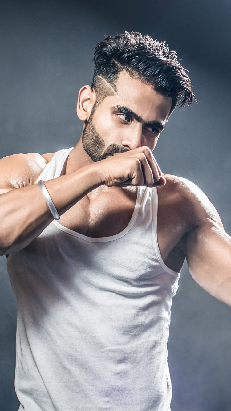 Man in White Tank Top Holding Blue and White Nike Boxing Gloves. Wallpaper in 750x1334 Resolution