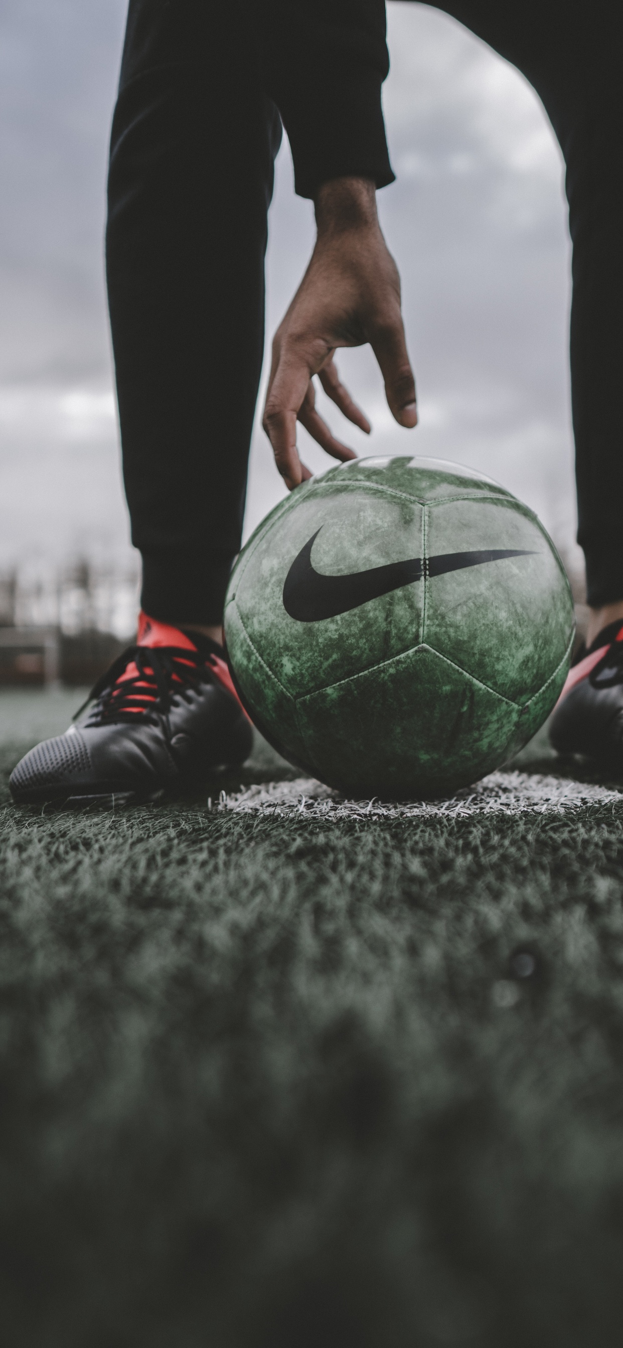 Person in Schwarzer Hose Und Rot-weißem Fußball. Wallpaper in 1242x2688 Resolution