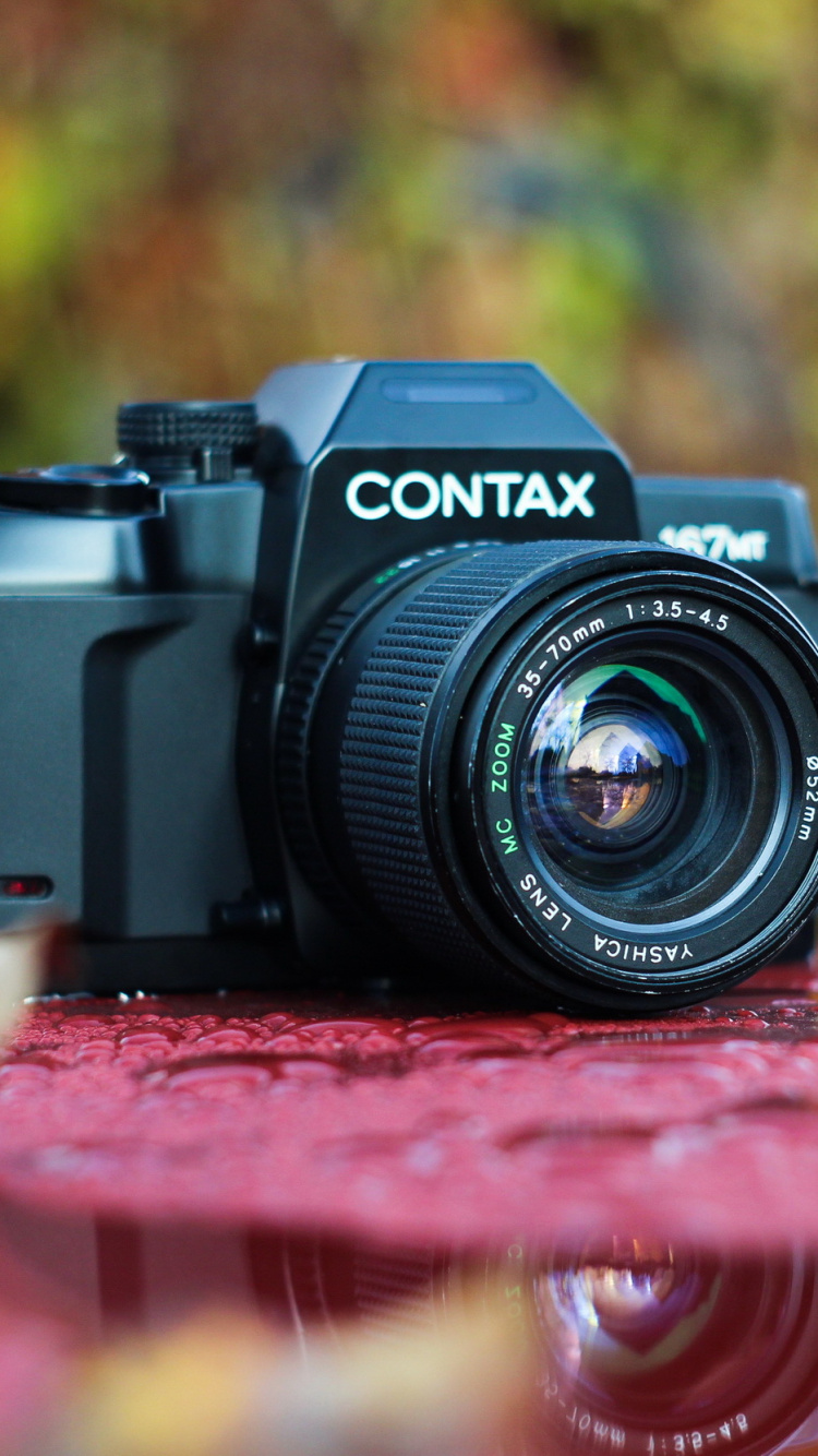 Schwarze Nikon Dslr Kamera Auf Rotem Textil. Wallpaper in 750x1334 Resolution
