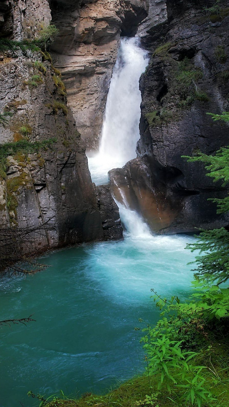 Cascadas Entre la Montaña Rocosa Marrón Durante el Día. Wallpaper in 750x1334 Resolution