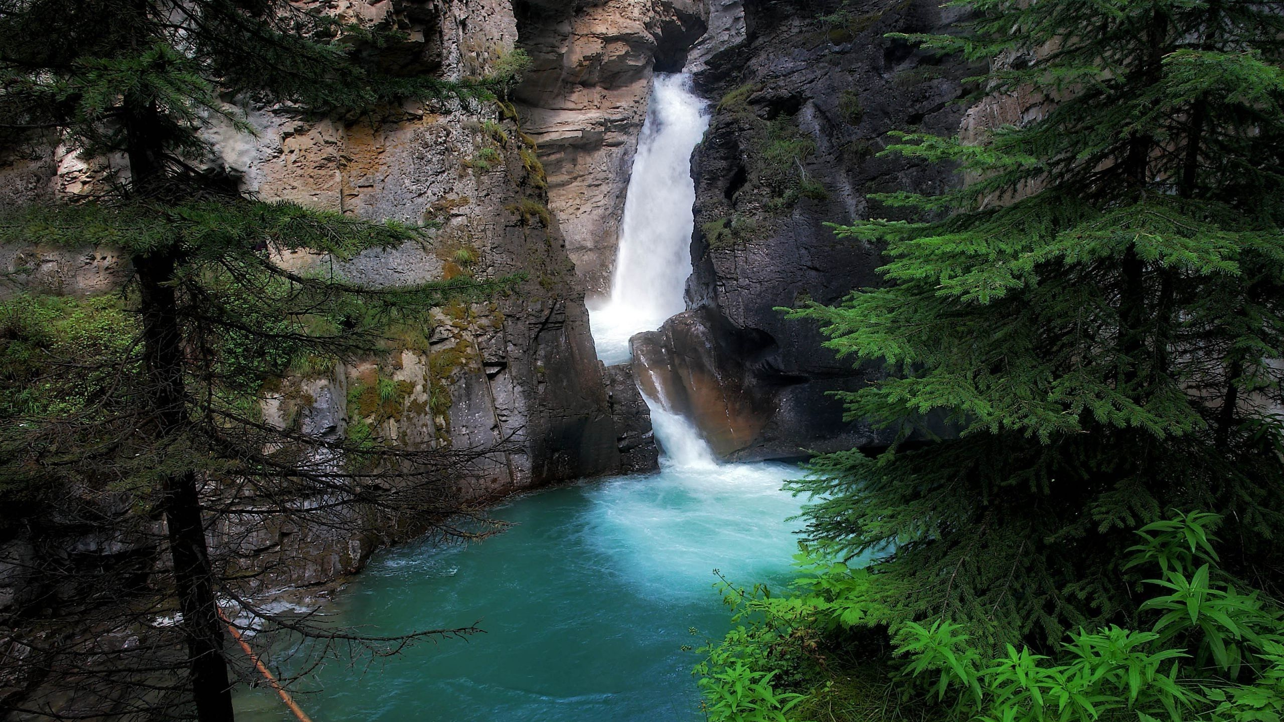 Waterfalls Between Brown Rocky Mountain During Daytime. Wallpaper in 2560x1440 Resolution