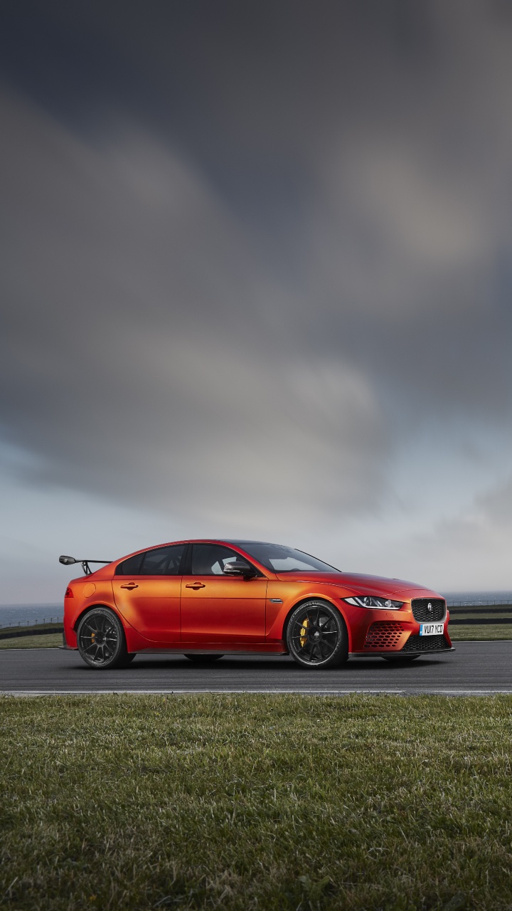 Red Coupe on Gray Asphalt Road Under Gray Cloudy Sky. Wallpaper in 720x1280 Resolution