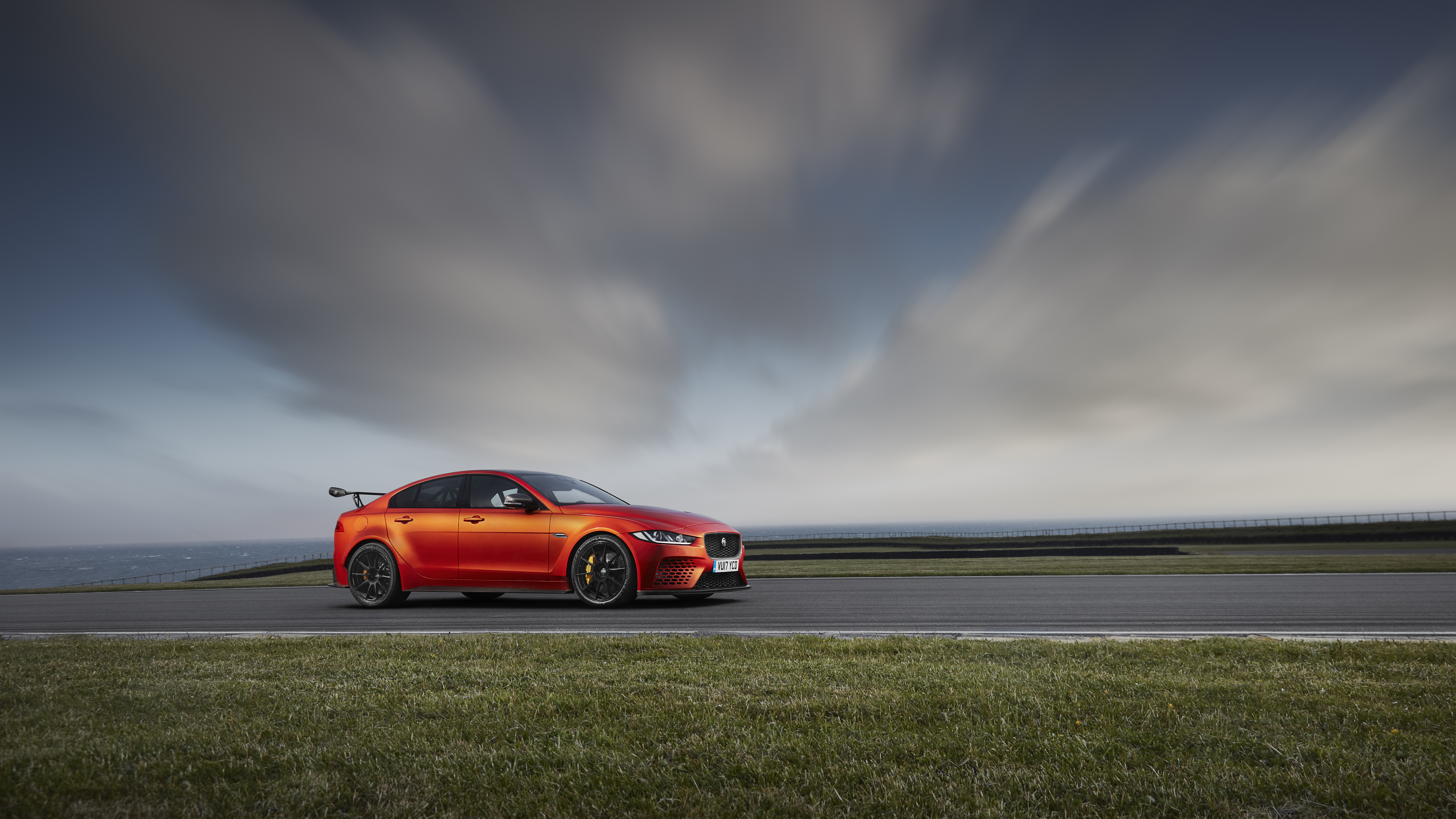 Coupé Rouge Sur Route Goudronnée Grise Sous Ciel Nuageux Gris. Wallpaper in 7680x4320 Resolution