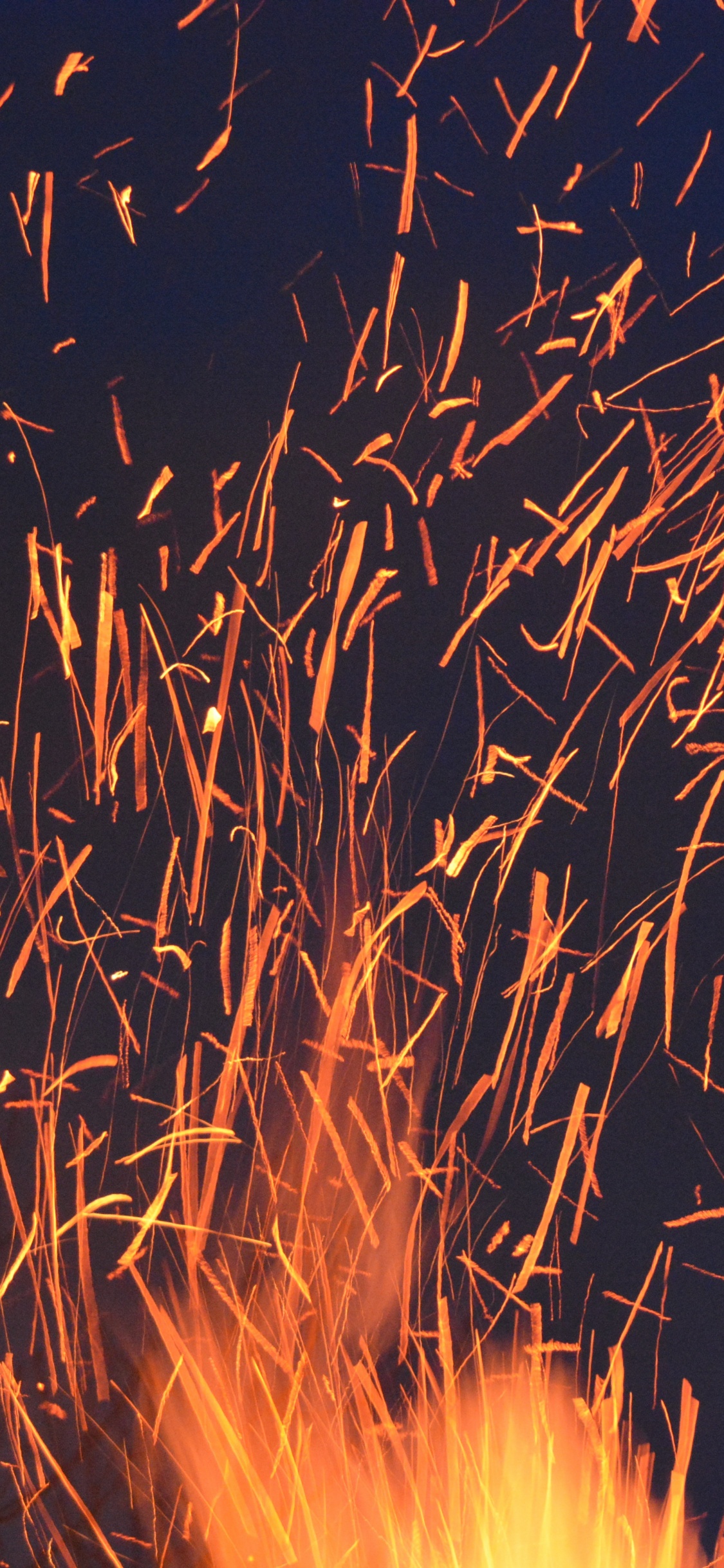 El Fuego Funciona en el Cielo Durante la Noche.. Wallpaper in 1125x2436 Resolution