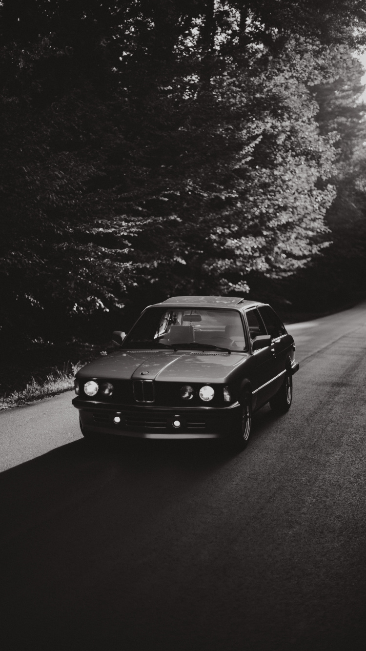Black Car on Road in Grayscale Photography. Wallpaper in 750x1334 Resolution