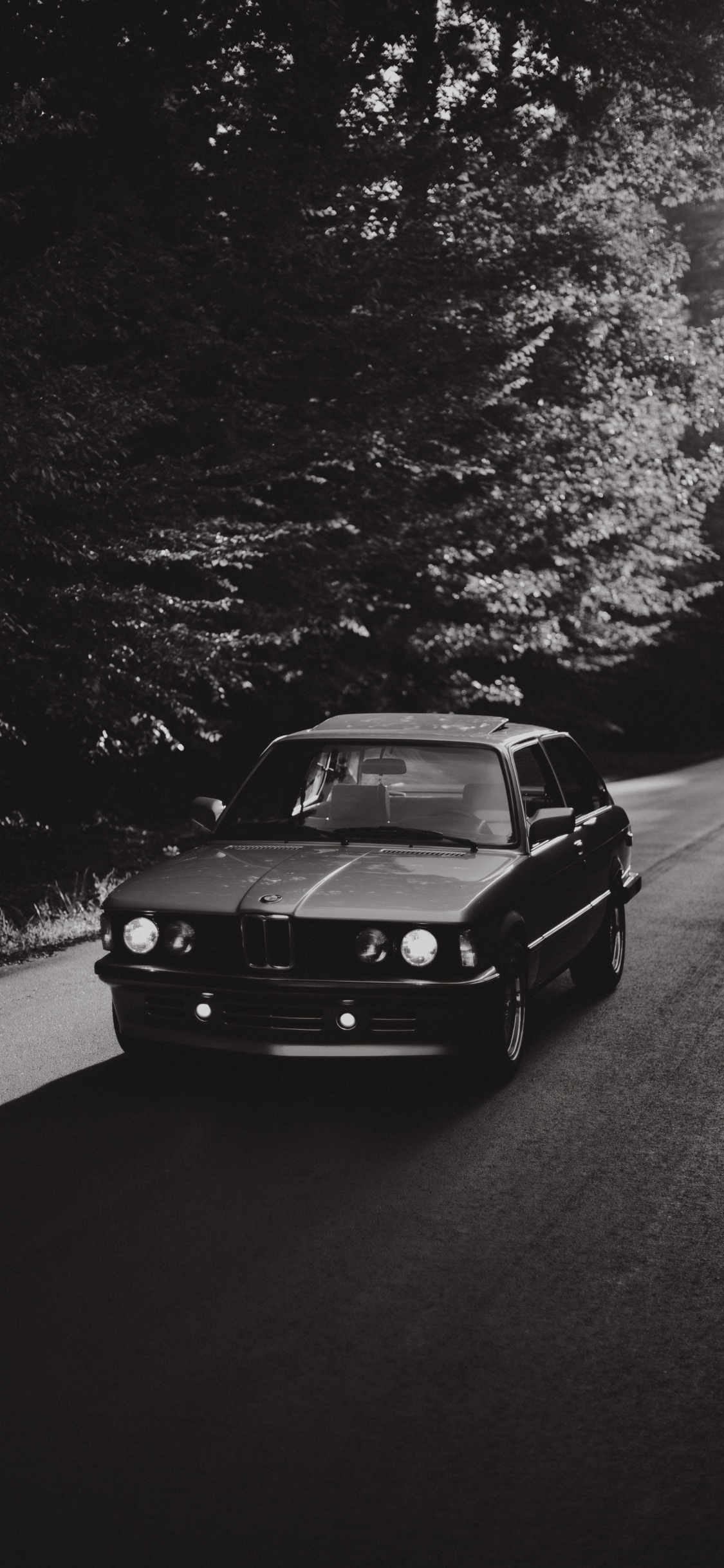 Voiture Noire Sur Route en Photographie en Niveaux de Gris. Wallpaper in 1125x2436 Resolution