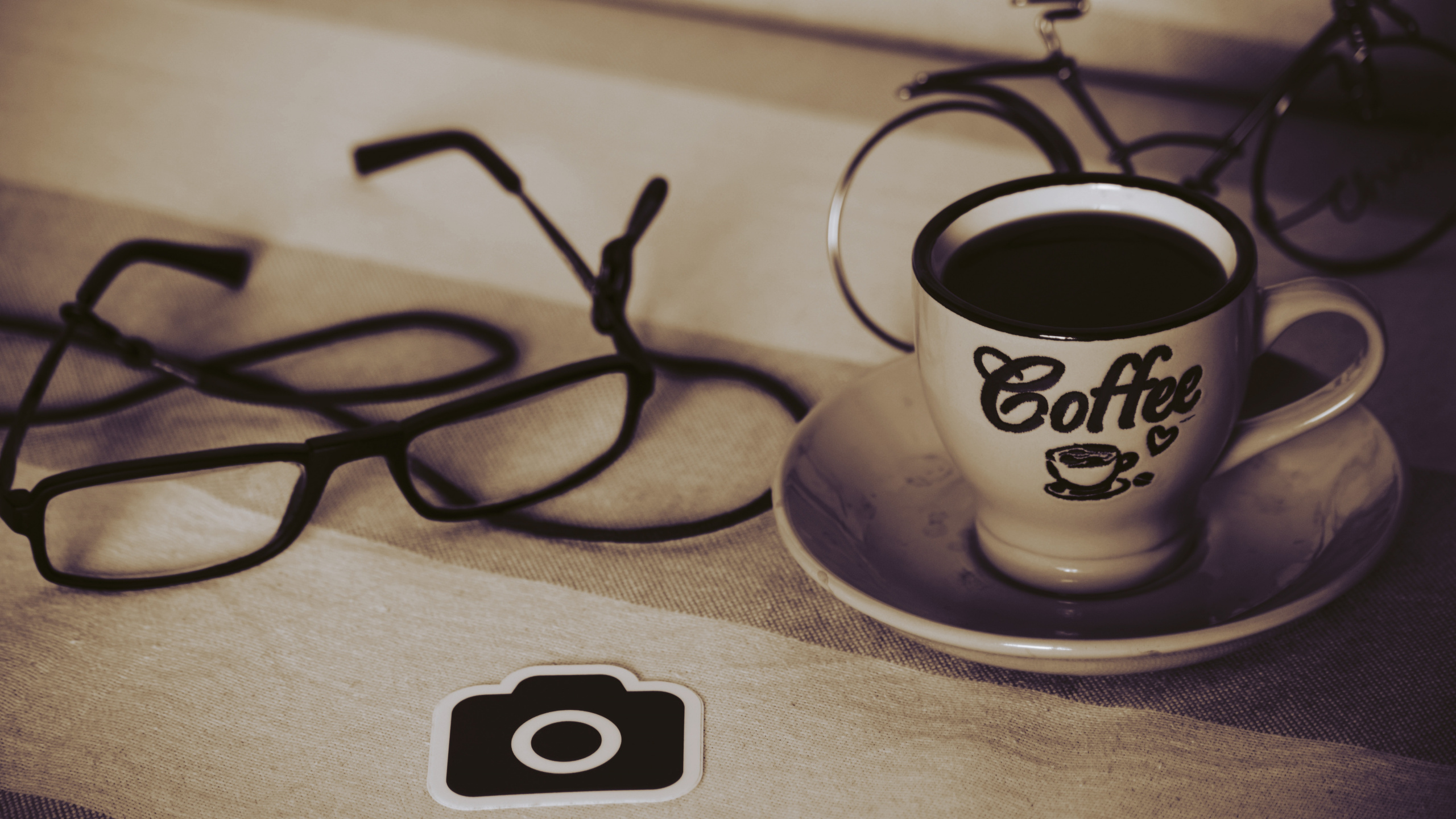 Black Framed Eyeglasses on White Ceramic Cup With Saucer. Wallpaper in 2560x1440 Resolution