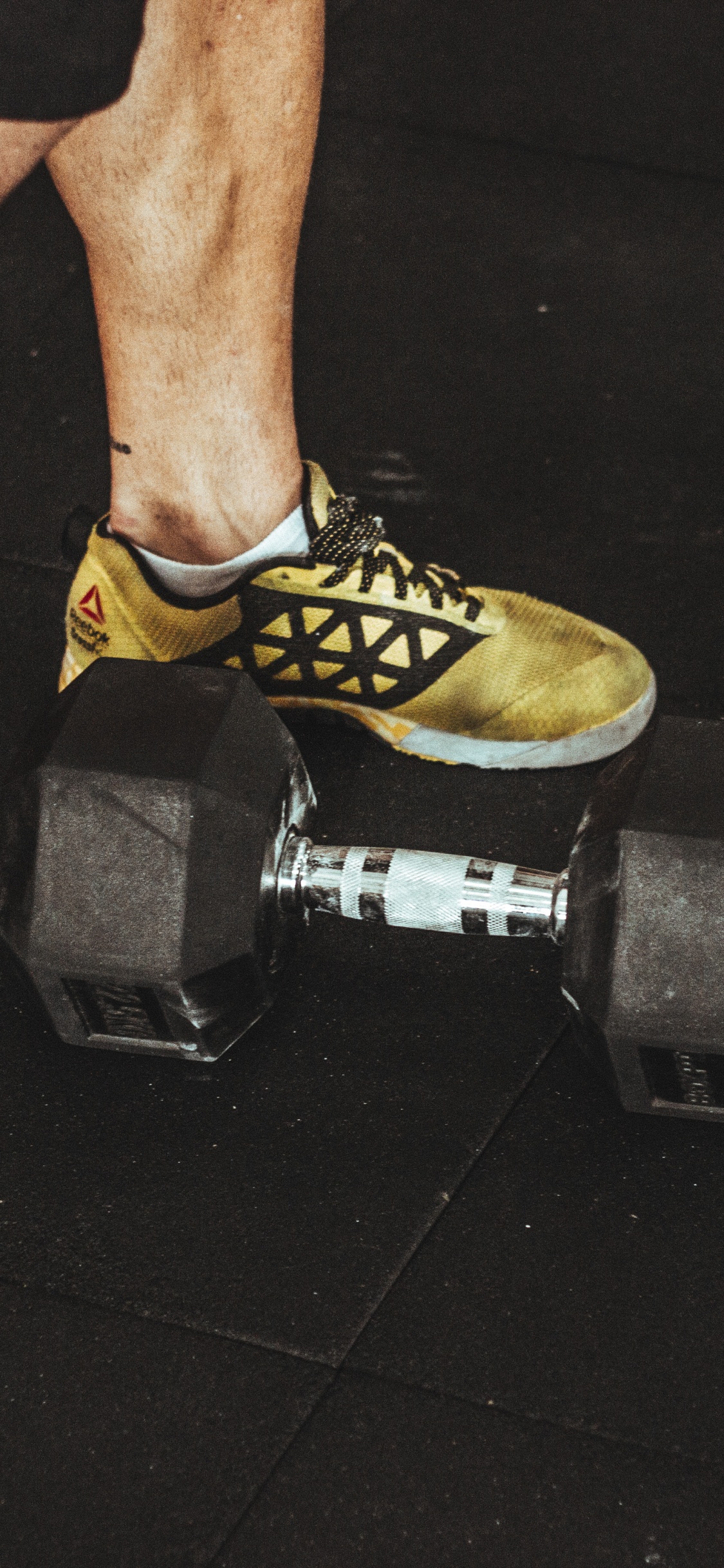 Persona Vistiendo Zapatos Deportivos Nike Amarillos y Negros. Wallpaper in 1125x2436 Resolution