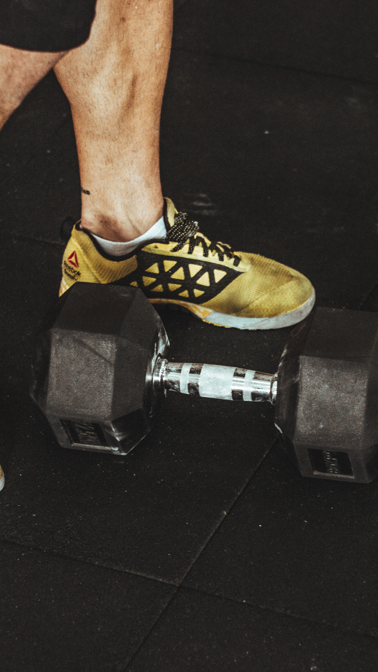 Persona Vistiendo Zapatos Deportivos Nike Amarillos y Negros. Wallpaper in 750x1334 Resolution