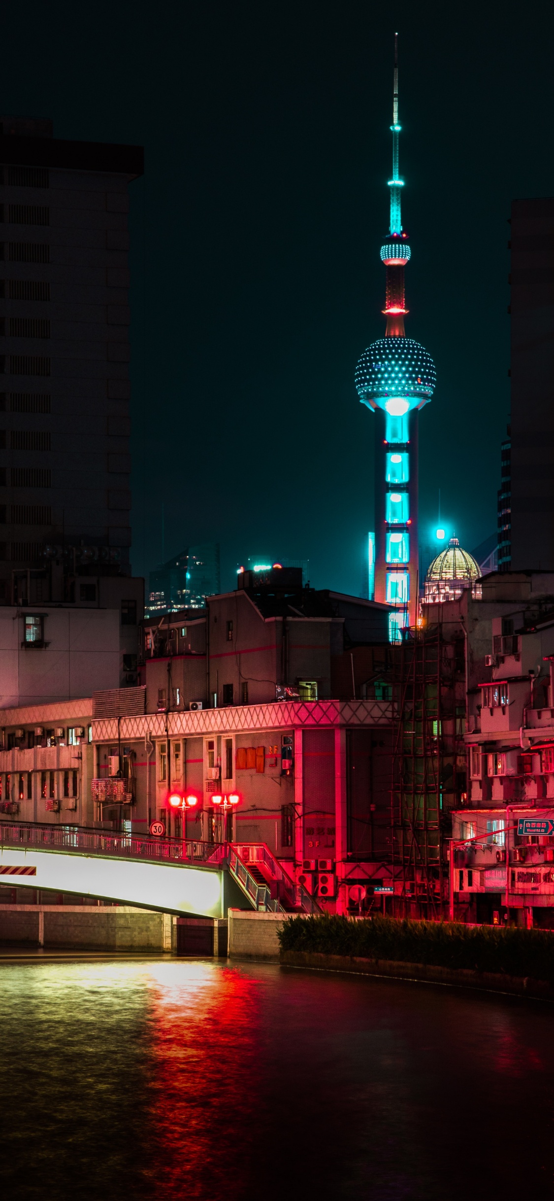 Bateau Blanc Sur L'eau Près Des Bâtiments de la Ville Pendant la Nuit. Wallpaper in 1125x2436 Resolution