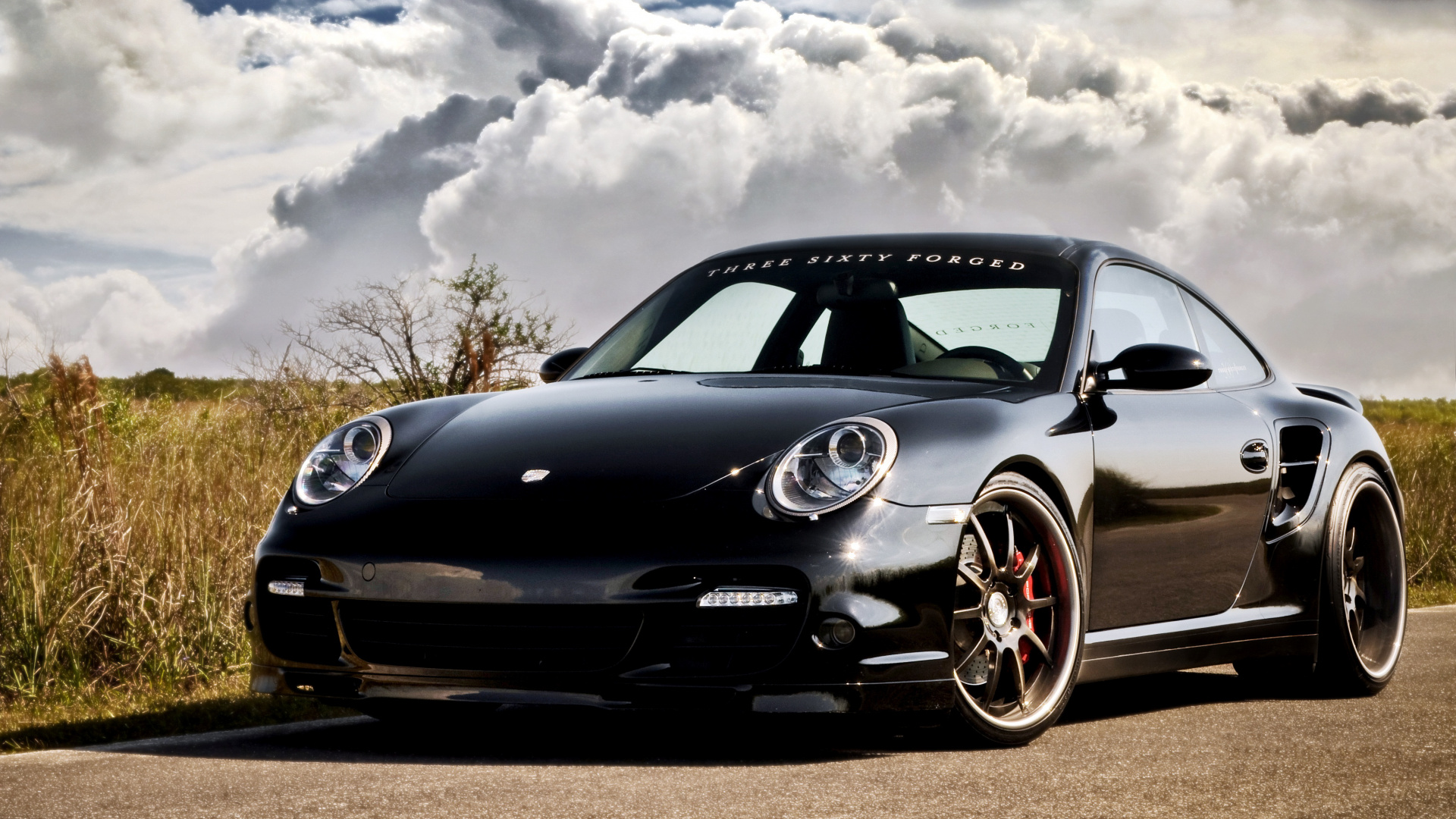 Schwarzer Porsche 911 Auf Braunem Feld Unter Weißen Wolken. Wallpaper in 1920x1080 Resolution