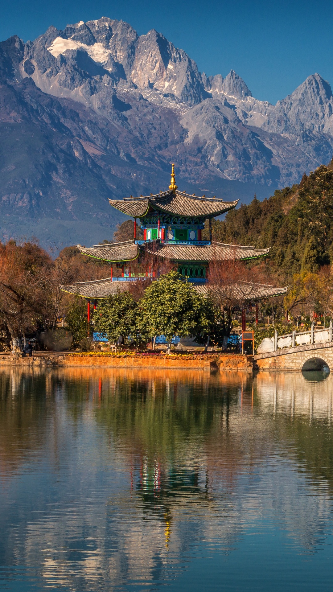 Brown Wooden Bridge Over River Near Mountain. Wallpaper in 1080x1920 Resolution