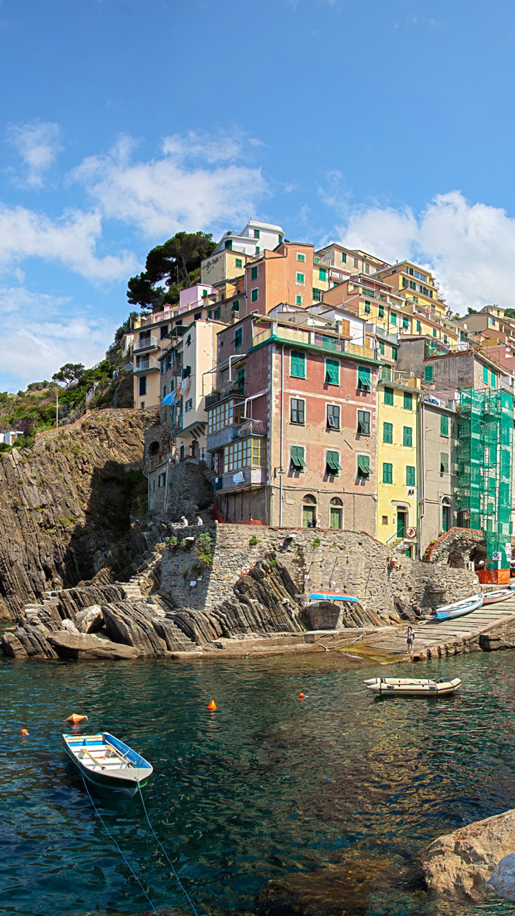 Barco Blanco en el Mar Cerca de Edificios de Hormigón Bajo un Cielo Azul Durante el Día. Wallpaper in 750x1334 Resolution