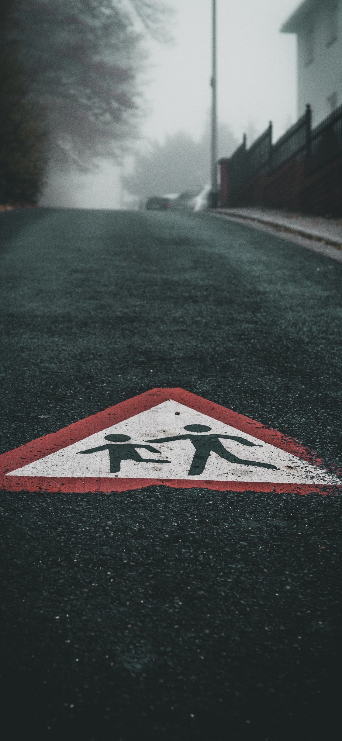 Black White and Red Arrow Sign on Road. Wallpaper in 1125x2436 Resolution