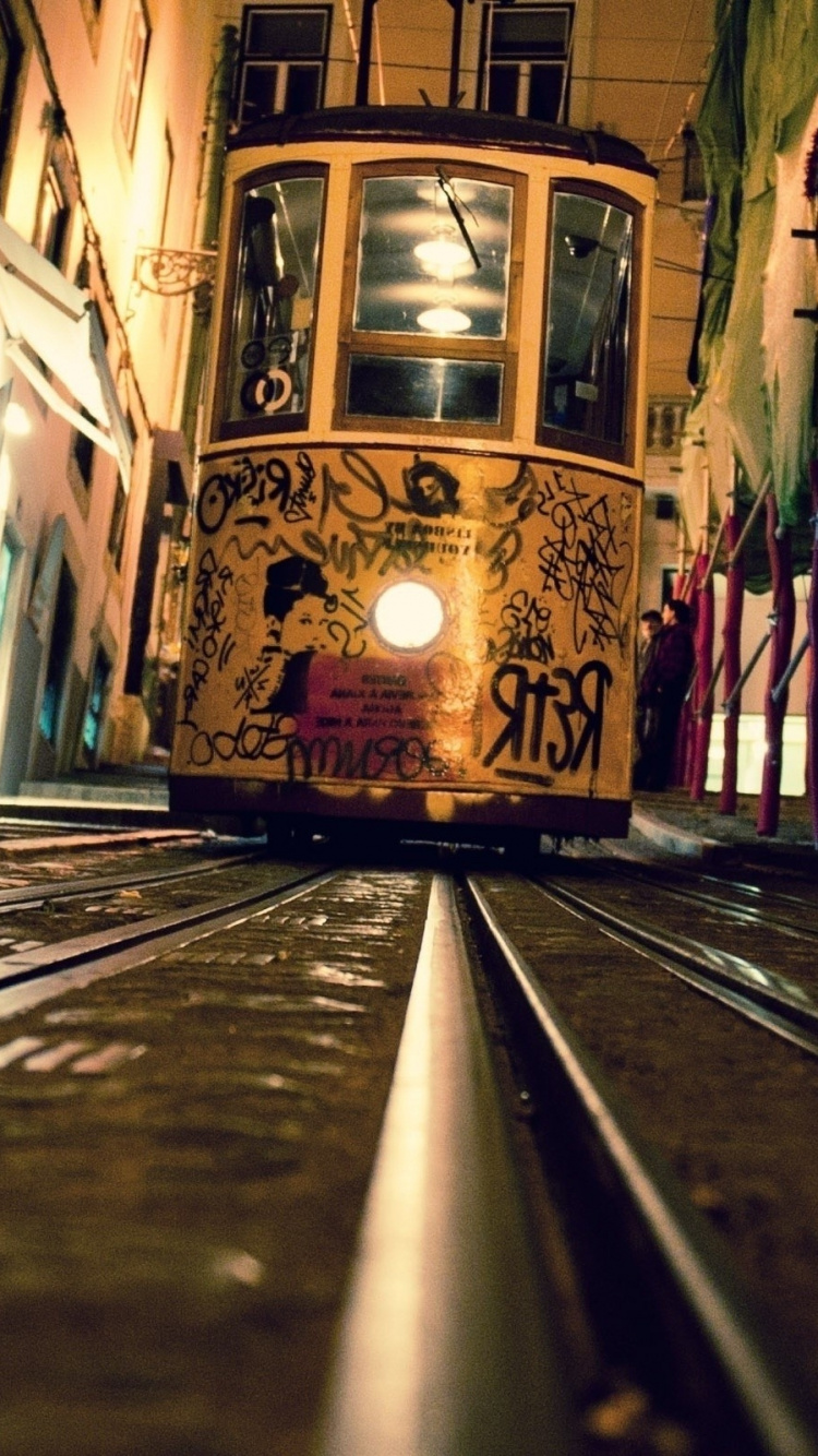 Gelbe Und Schwarze Straßenbahn Tagsüber Unterwegs Road. Wallpaper in 750x1334 Resolution