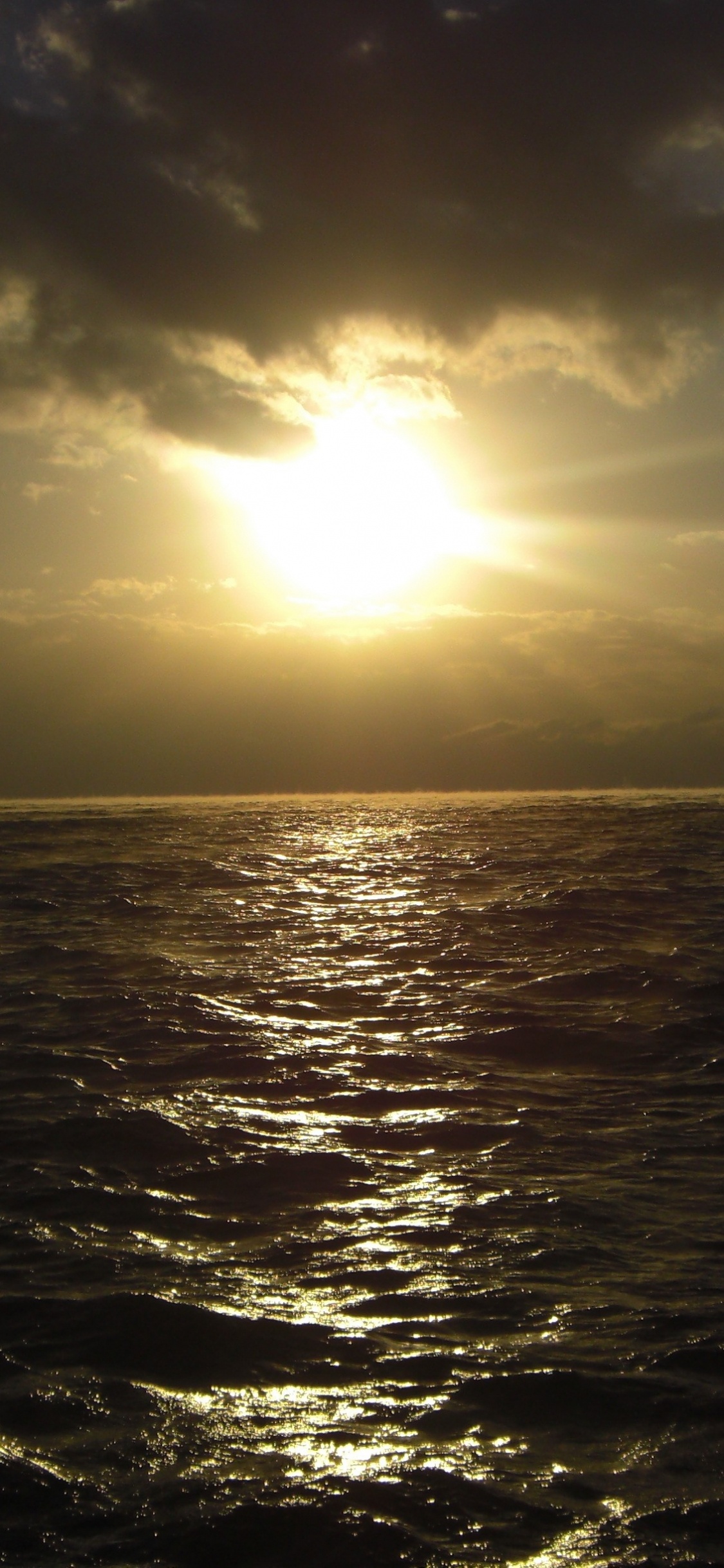 Body of Water Under Blue Sky During Daytime. Wallpaper in 1125x2436 Resolution