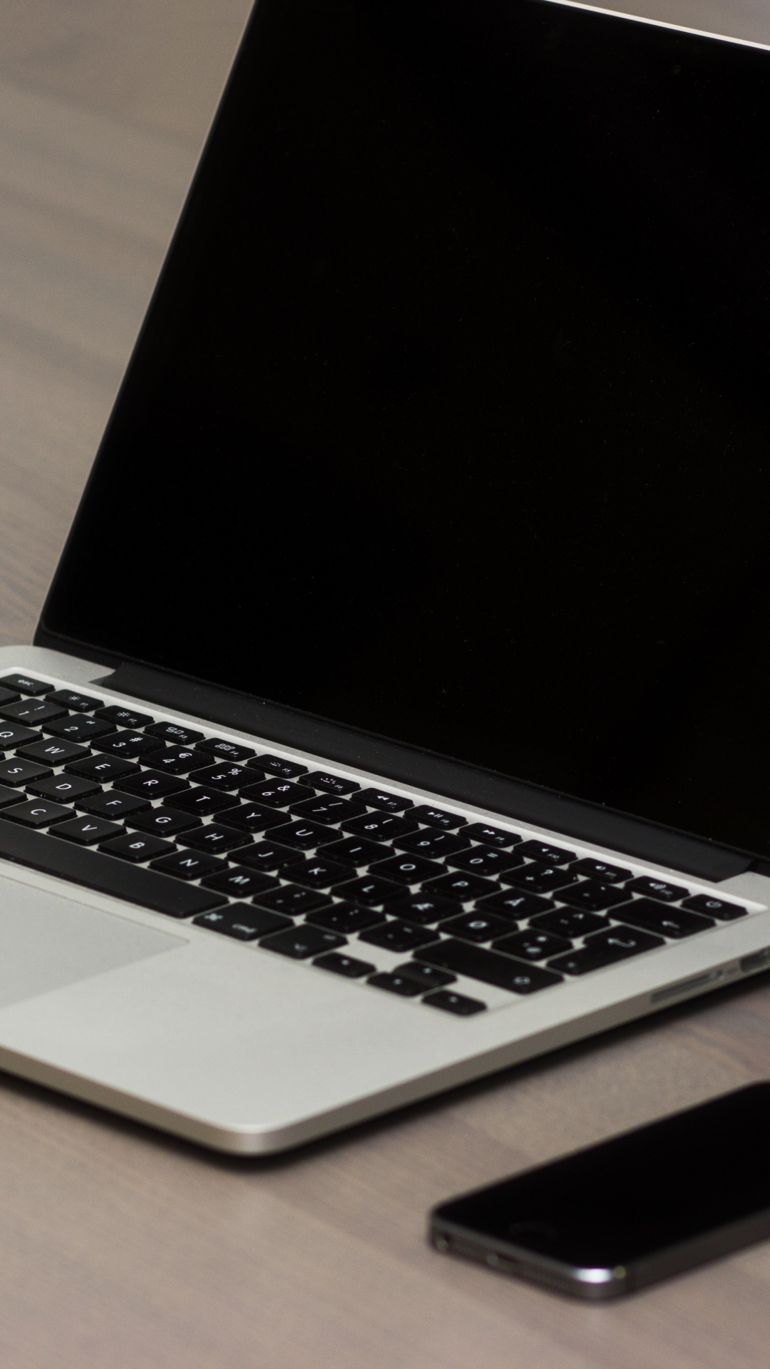 Macbook Pro Beside Black Smartphone on Brown Wooden Table. Wallpaper in 1080x1920 Resolution