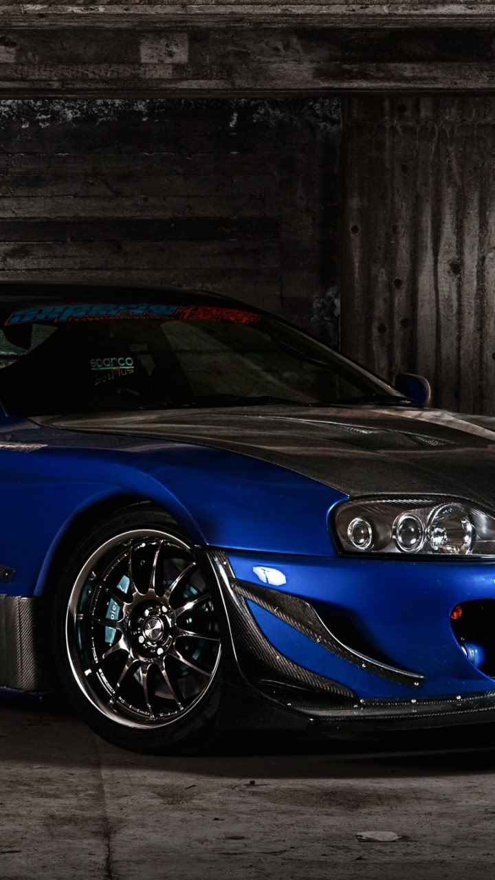 Blauer Porsche 911 Neben Grauer Wand Geparkt. Wallpaper in 720x1280 Resolution