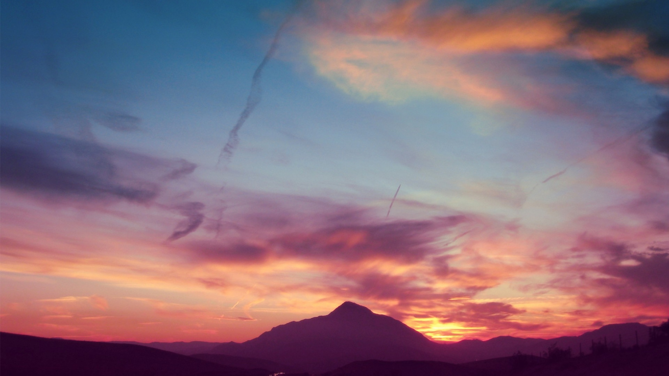 Silhouette de Montagnes Sous un Ciel Nuageux Pendant le Coucher du Soleil. Wallpaper in 1366x768 Resolution