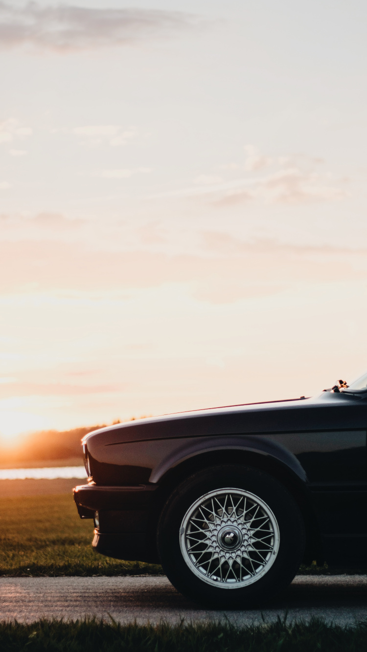 Schwarzes Auto Auf Braunem Feld Tagsüber. Wallpaper in 750x1334 Resolution