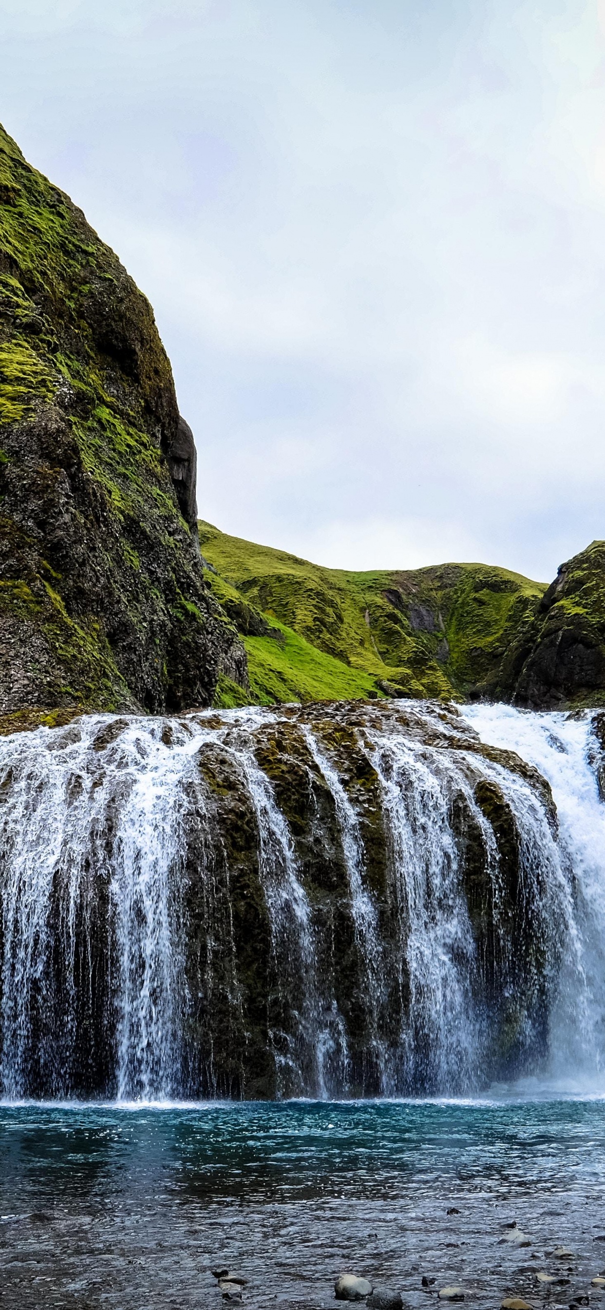 Waterfalls on Green Mountain Under White Sky During Daytime. Wallpaper in 1242x2688 Resolution